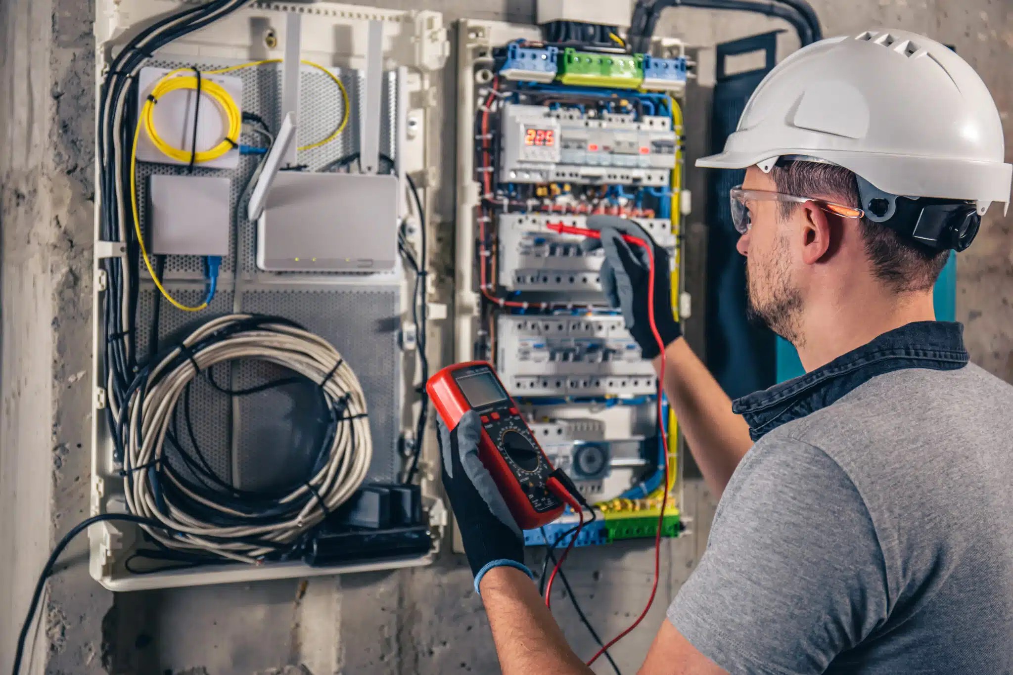 Électricien réparant un tableau électrique modulaire, gros plan sur les mains